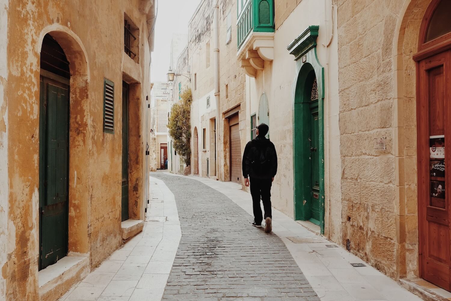A tourist wanders a narrow street in Valetta, Malta