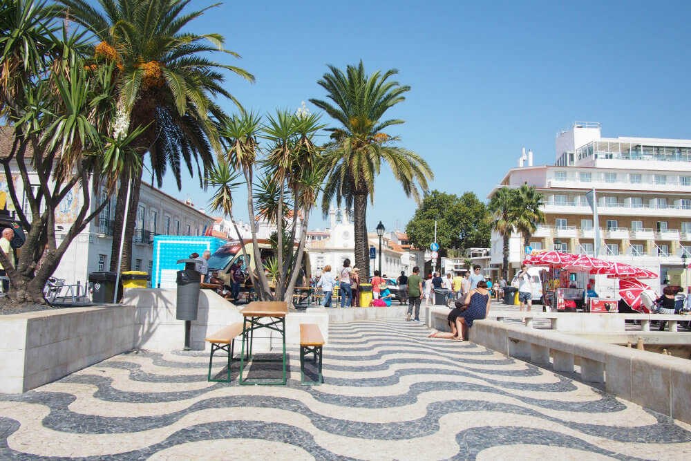 The wavy black and white tiles and palm tress of Cascais, Portugal