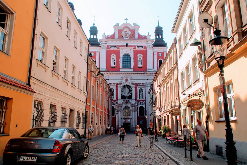 The red facade of a church dominates the end of the street in central Poznan, Poland