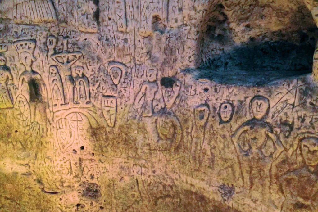 The walls of the cave are covered in etchings