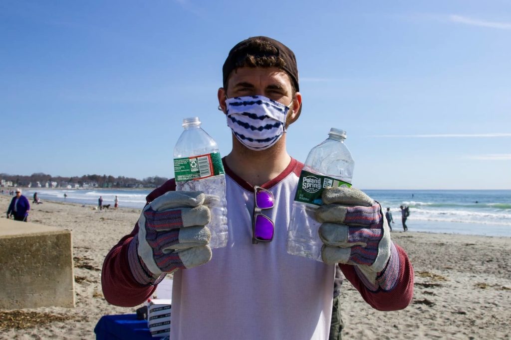 Man showing plastic bottles found on beach clean