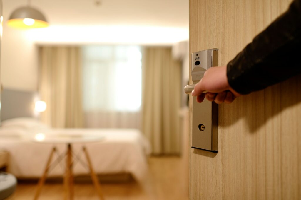 A person opening the door to a hotel room