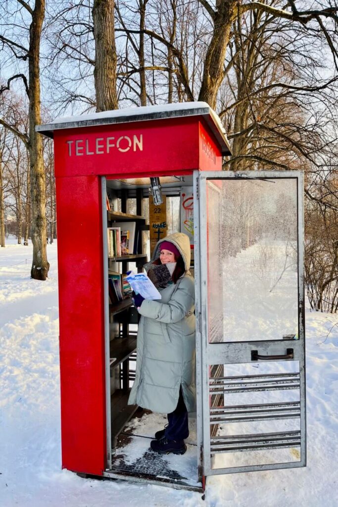 Jade checks out some of the book choices inside a telephone box during a winter visit to Oslo.